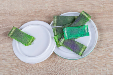 snus. tobacco in bags. the background is wooden in a retro style. there is a tinting. close-up.