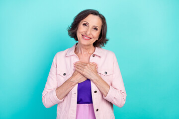 Photo portrait woman in casual clothes smiling thankful keeping hands on chest isolated vibrant teal color background