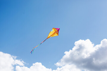 Fototapeta na wymiar A multicolored kite soars in the sky