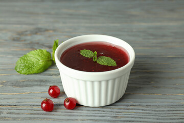 Bowl of cranberry sauce on gray wooden background