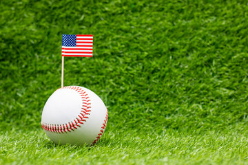 Baseball with flag of America on green grass background