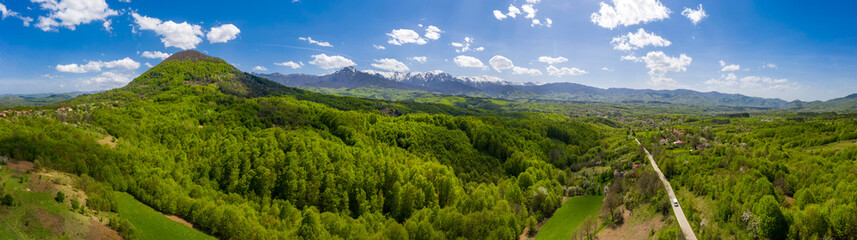 Fototapeta na wymiar panoramic view from drone of the mountain with green hills and road in spring