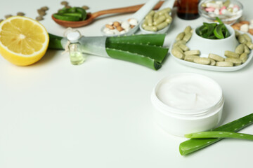 Concept of herb pills and cosmetics with aloe on white background