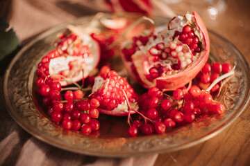 red ripe pomegranate lying on a golden platter