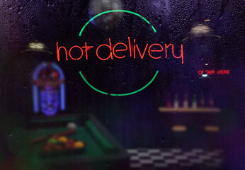 Neon Hot Delivery Sign in Rainy Window