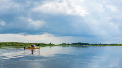 Obraz na płótnie Canvas Kayaking on the Elbe river under a dramatic sky