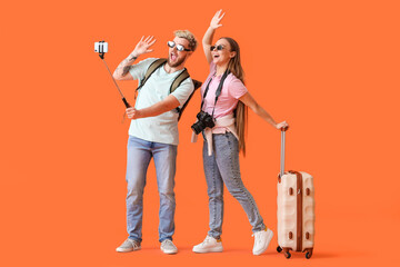 Couple of tourists taking selfie on color background