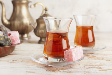 Glasses of tasty Turkish tea and delights on table
