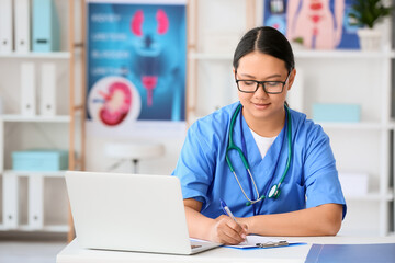 Female Asian doctor sitting at table in clinic
