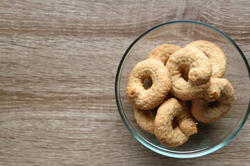 Bowl of biscuits on wooden table. Top view.