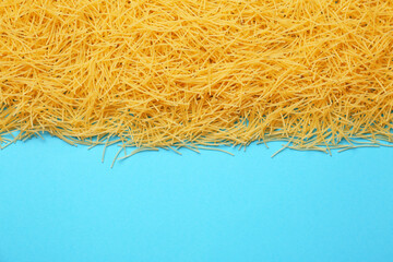 Uncooked vermicelli pasta on color background