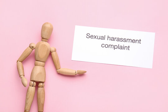 Paper with text SEXUAL HARASSMENT COMPLAINT and mannequin on color background