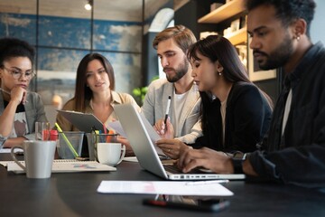 Group of young multiracial people working in modern office. Businessmen at work during meeting.