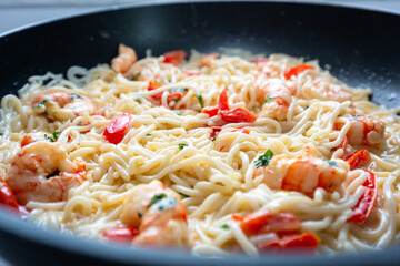 Noodles with prawns in cream sauce with cherry tomatoes