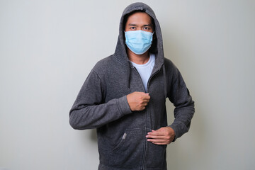 A man zip his hoodie and wearing protective medical mask © KrishnaTedjo
