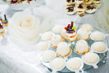 Obraz na płótnie Canvas Delicious sweets on wedding candy buffet with desserts, cupcakes