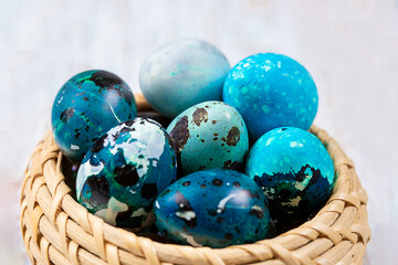 Easter blue quail eggs in a wicker basket