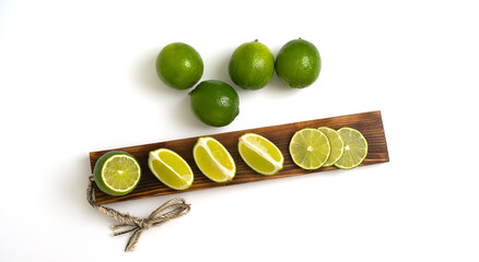 Sliced fresh lime on a wooden kitchen board on a white background. Preparation of the concept for...