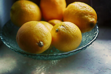 Glass plate with lemons, still life close up soft focus