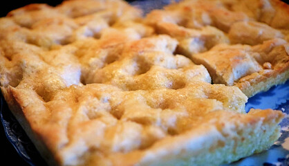 Genoa-style focaccia, typical slow food bread of ancient tradition, close up soft focus