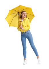 Beautiful young woman with umbrella on grey background