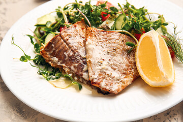 Plate with tasty baked cod fillet and vegetables on light background, closeup