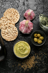 Bowl with tasty baba ghanoush and fresh ingredients on dark background