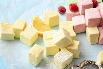Tasty sweet marshmallows, orange and raspberries on color background