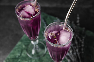 Glasses of fresh cocktail with lavender on dark background, closeup