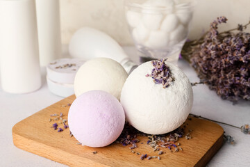 Lavender bath bombs, flowers and cosmetics on light background