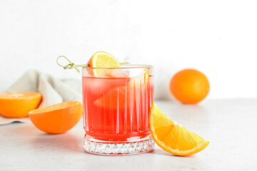 Fototapeta na wymiar Glass of tasty Negroni cocktail on light background