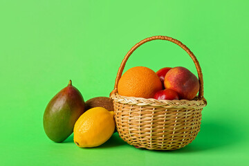 Basket with fresh fruits on color background