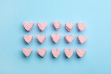Sweet heart shaped marshmallows on blue background