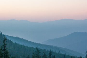 Blurred background smoky mountain landscape with mountain silhouette at sunset.