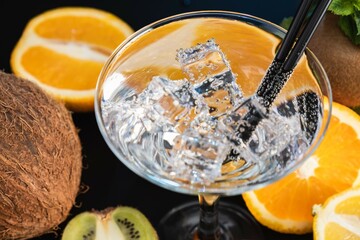 Iced drink on a background of tropical fruits top view close-up.