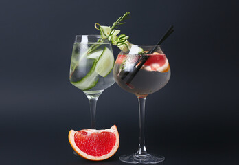 Glasses of cold gin tonic on dark background