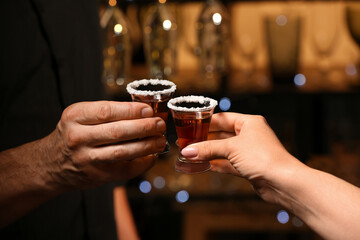 Friends with shots of tasty tequila in bar