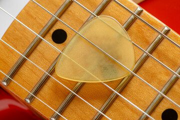 Detail of the neck, the pickup and the strings of a red electric guitar
