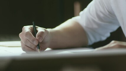 closeup shot of designer's hand sketching on paper when thinking indoors
