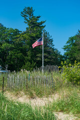 American flag flying on a pole at a Michigan beach
