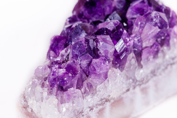 Macro mineral stone purple amethyst in crystals on a white background