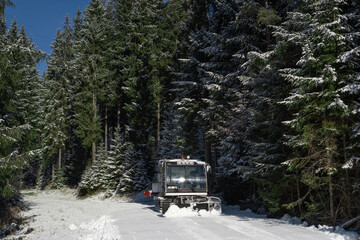 Snowplow machine at snowy ski resort. Modern snowcat ratrack. Snowcat vehicle. Snow tracks waiting