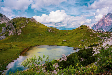 Fototapeta na wymiar Valparola Pass with hut and with Lake Valparola in the foreground, Italy.