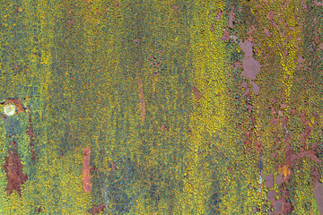 Background of cracked multilayer paint on a rusty metal wall. Small texture.