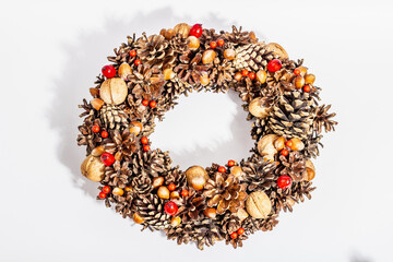 Autumn wreath of cones, nuts, and berries isolated on white background