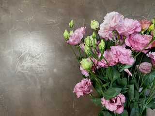 bouquet of pink eustoma flowers, isolated on brown with place area for text