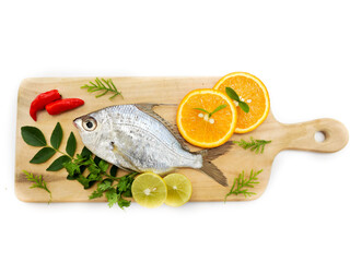 Gerres Fish (Gerres Filamentosus) , Whipfin silver biddy Fish , Decorated with curry Leaves and Tomato on a Wooden pad,White Background.Selective focus.