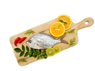 Gerres Fish (Gerres Filamentosus) , Whipfin silver biddy Fish , Decorated with curry Leaves and Tomato on a Wooden pad,White Background.Selective focus.
