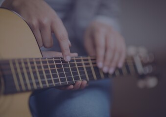 Close up of mid section of a person playing a guitar