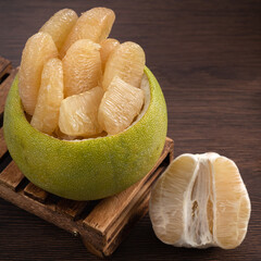 Fresh pomelo fruit on wooden table background.